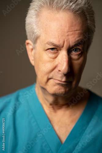 Photo of an old medical doctor crying with tears on face