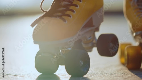 Yellow rollerblades for unknown female skater staying outdoors. Sports concept. photo