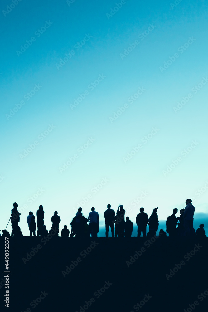 Naklejka premium Silhouettes of tourist crowd waiting for the sunrise and doing activity, taking a photo, selfie with nature on the hill at viewpoint