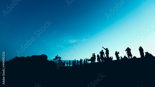 Silhouettes of tourist crowd waiting for the sunrise and doing activity, taking a photo, selfie with nature on the hill at viewpoint © PPstock