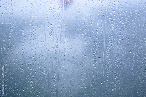 Fotografie Raindrops on glass with blurred blue background