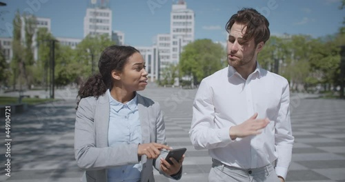 Partnership problems. African american woman and caucasian man colleagues going together outdoors photo