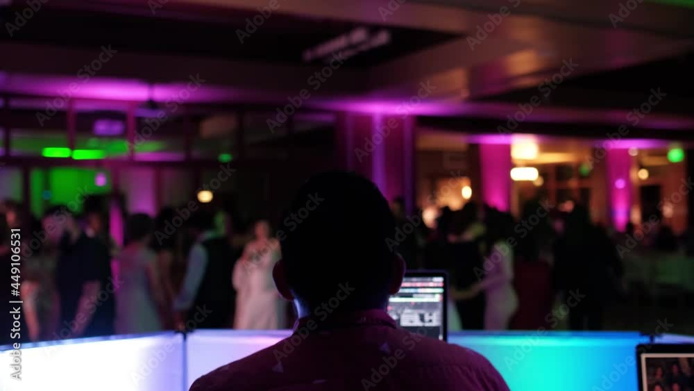 Behind the wedding DJ while guests are dancing