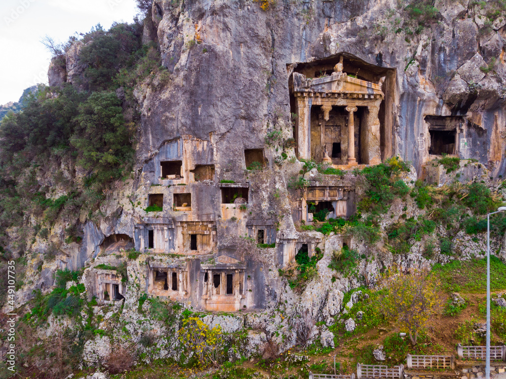 Modern view of remains of ancient Telmessos rock hewn tombs in stone cliff in city of Fethiye, Mugla Province, Turkey