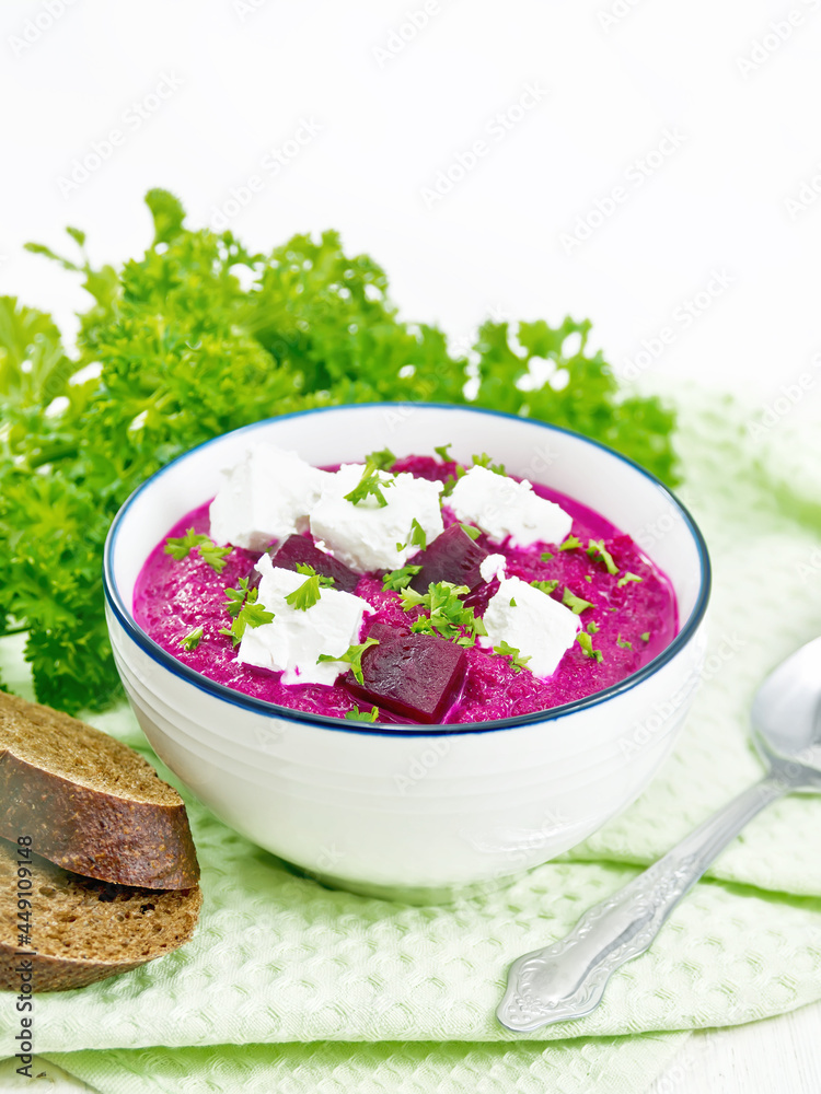 Soup puree of beetroot with feta in bowl on white board Soup puree of beetroot with feta in bowl on white board