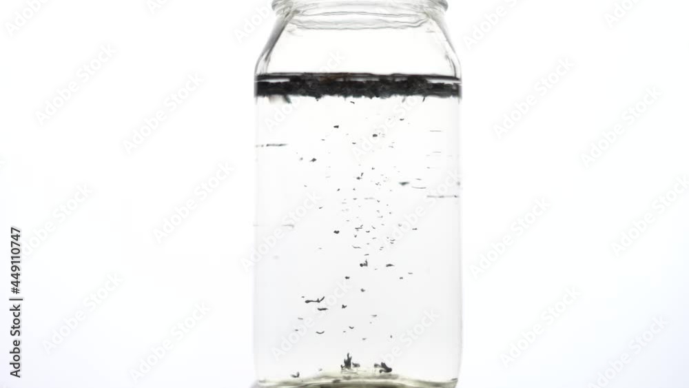 clear water throughing green tea leavs in water slow motion timelaps. clear water throughing green tea leavs in water slow motion timelaps.