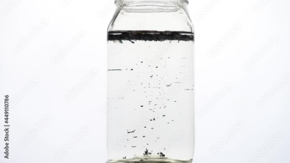 clear water throughing green tea leavs in water slow motion clear water throughing green tea leavs in water slow motion