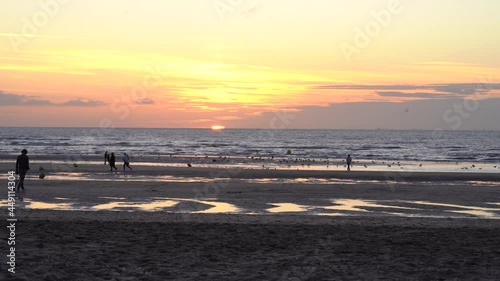 Deauville sur Mer Channel beach with people - silhouette walking during sunset in France photo