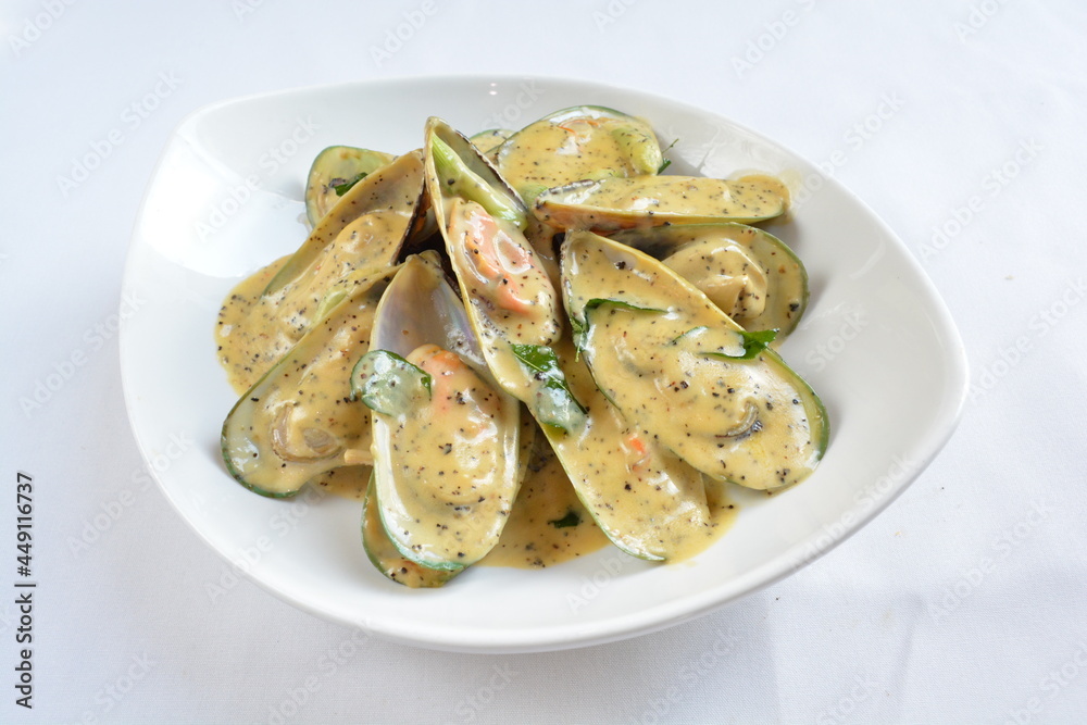 stir fried muscle clam shell seafood with cheesy black pepper cream sauce in white background asian halal menu