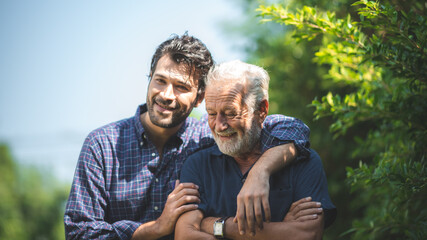 caucasian senior father and adult son are hugging together at home, generation family are happy with people love, male mature, old person man, elderly grandfather smiling living at the house
