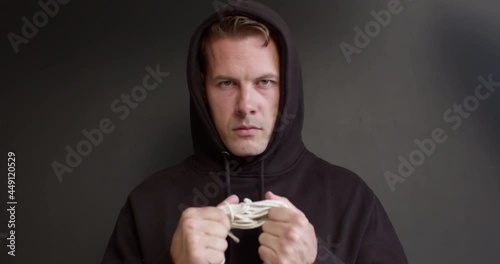 Human trafficking concept. Stop violence against Women. Maniac man holding rope, suspicious dangerous man threatens someone, looking at camera. human rights, crime, kidnapping, violence concept