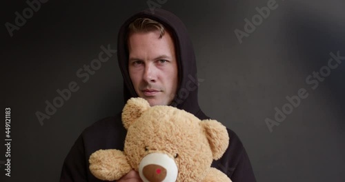 Dangerous maniac in black wear offers toy to the child. Kids in danger. Children safety protection kidnapping concept. Caucasian adult male is going to commit crime, lures children with toy