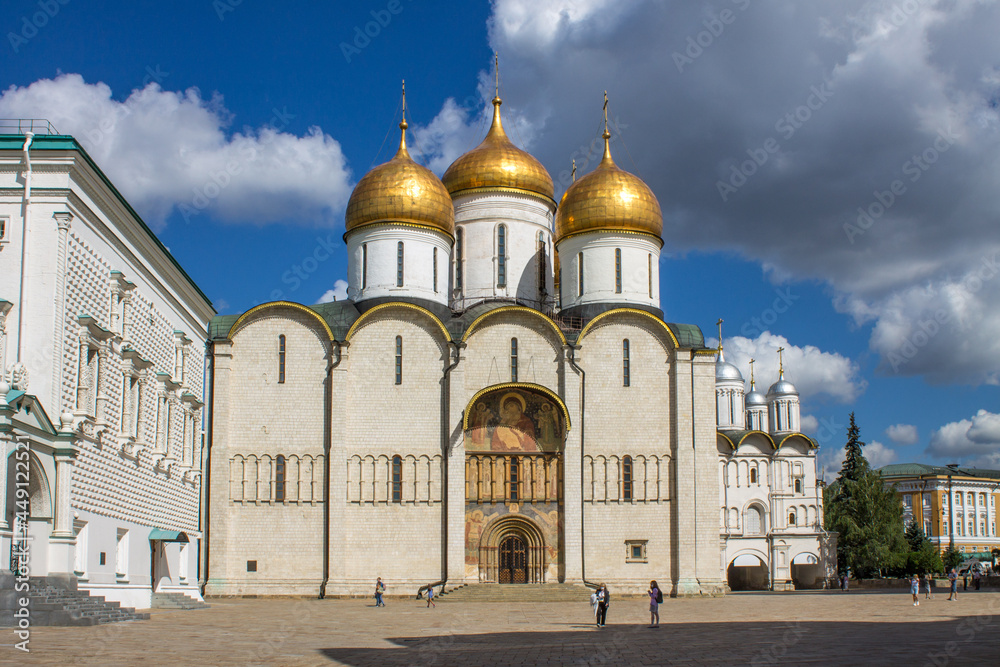 MOSCOW, RUSSIA-AUGUST, 4, 2021: the white-stone Assumption Cathedral with golden domes on the Cathedral square of the Kremlin on a sunny summer day