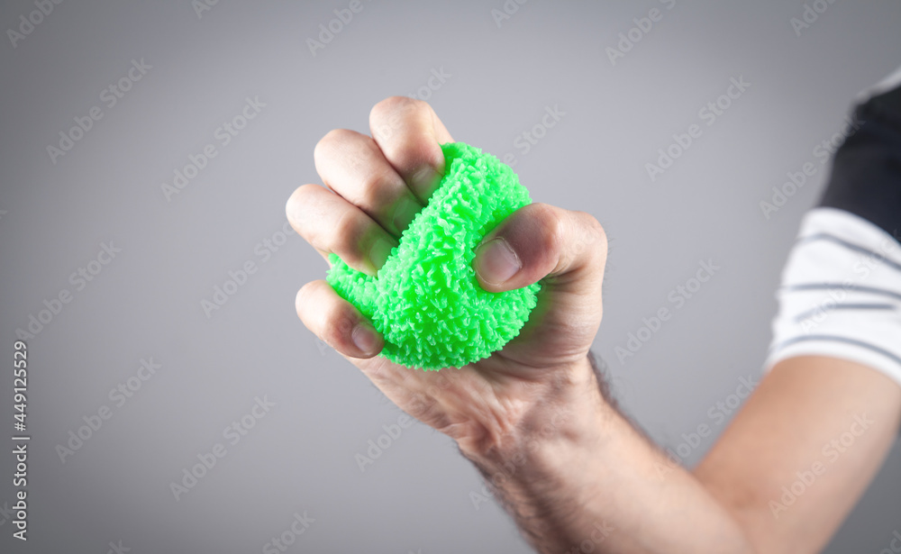 Male hand holding green stress ball. Male hand holding green stress ball.