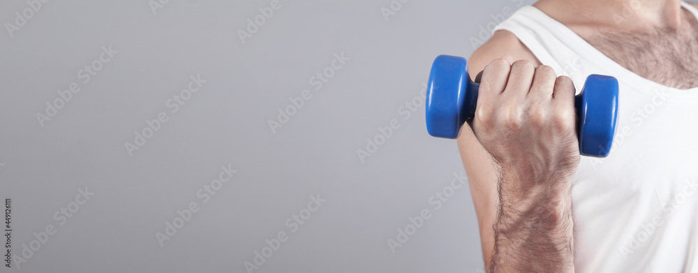 Caucasian man holding blue dumbbell. Caucasian man holding blue dumbbell.