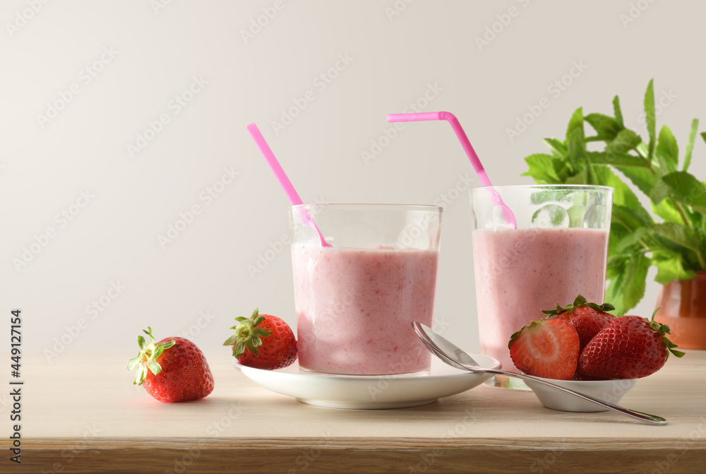 Glasses with strawberry shake on table full of fruits isolated Glasses with strawberry shake on table full of fruits isolated