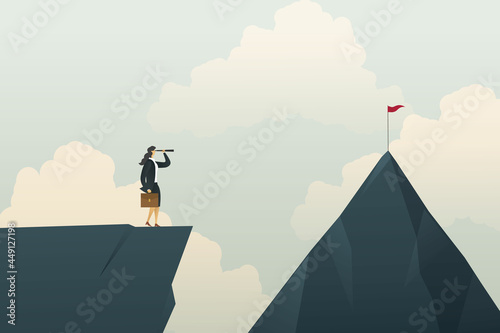 Businesswoman looking through a binoculars for way to goal at the mountain on which will climb