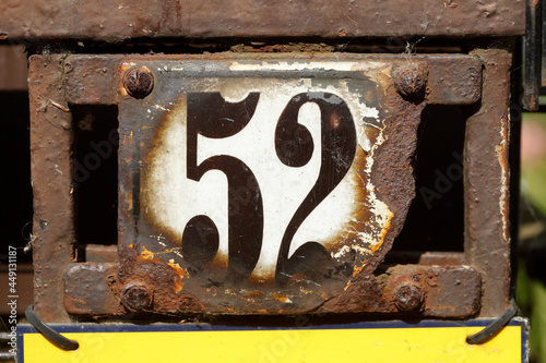 Altes verwittertes Hausnummernschild Nummer Zweiundfünfzig und verzierter Metallgartenzaunzaun, Bremen, Deutschland, Europa photo