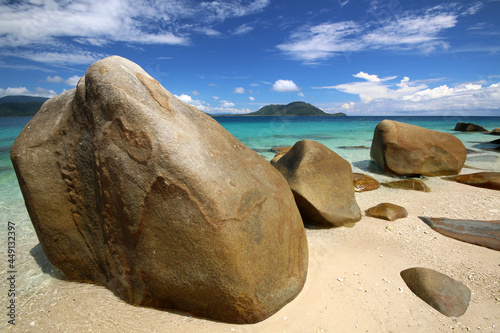 a rocky beach next to a tropical body of water
