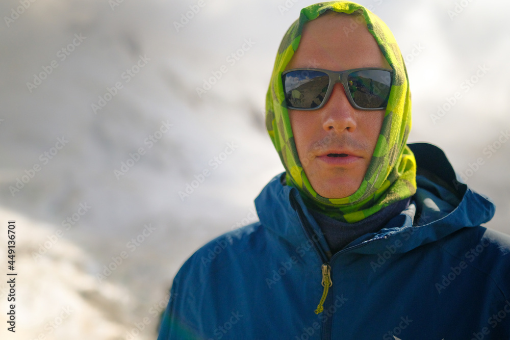Portrait of a man in a green buff and mountain sunglasses. Portrait of a man in a green buff and mountain sunglasses.
