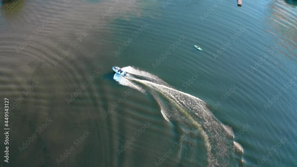 Blue boat on the river at sunset. People sailing in boats among beautiful landscape in the evening. Rest in summer. Aerial view Blue boat on the river at sunset. People sailing in boats among beautiful landscape in the evening. Rest in summer. Aerial view