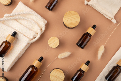 Eco friendly cloth shopping bag with amber glass dropper bottles different sizes with bamboo lid. Zero waste concept. Top view on beige background. Skincare natural cosmetic.