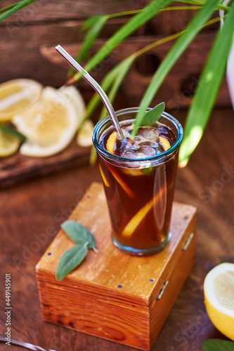 Espresso tonic. Lemon, sage. Side view, wooden background.