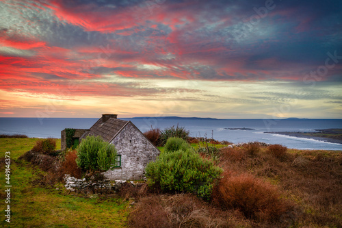 Fototapeta Beautiful sunset over the Atlantic Ocean with a small cottage house in Doolin, Co