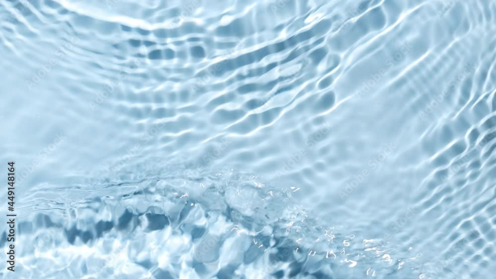 Multiple waves of water cross each other creating ripples spontaneously on pale blue background | Beauty background shot for skin care cosmetics advertisement