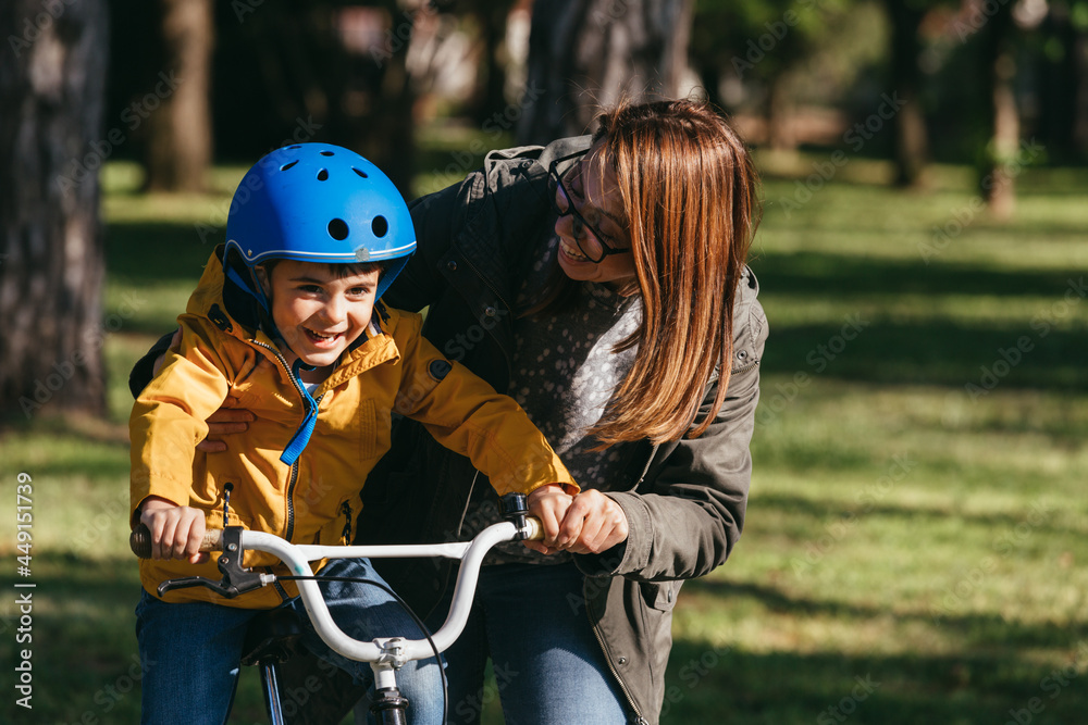 Obraz premium mother and son outdoors. riding bike