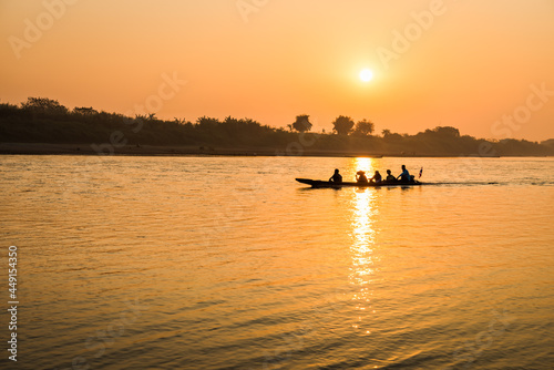 Fishermen in the boat on sunrise background