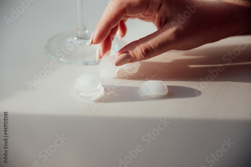 A woman's hand holds a glass with ice