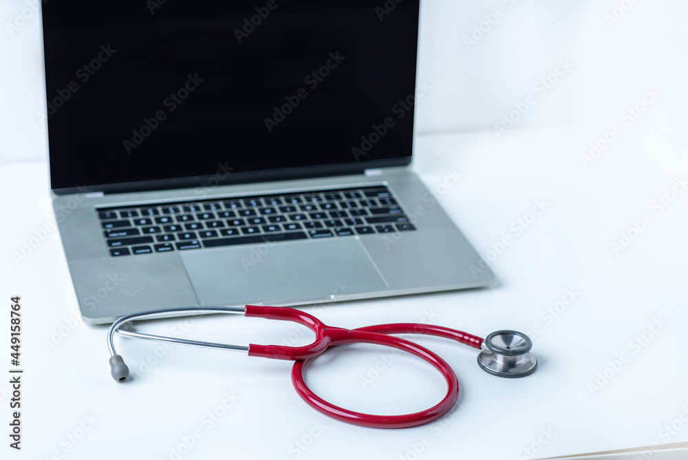 Stethoscope and computer on white desk in white background Stethoscope and computer on white desk in white background
