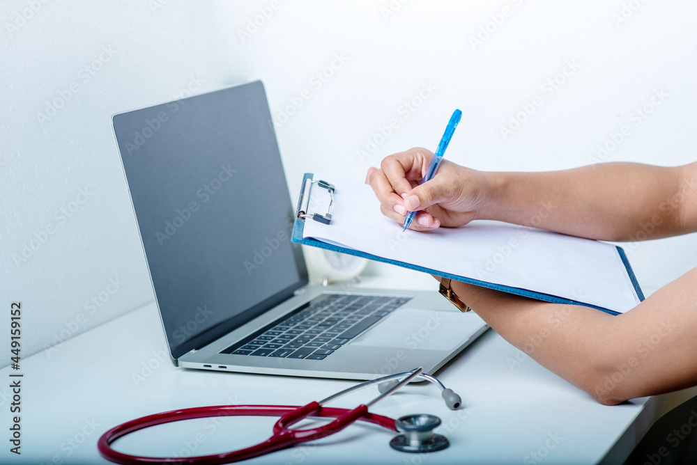 the doctor is analyzing the illness A stethoscope and computer are placed on a white desk in a white background. the doctor is analyzing the illness A stethoscope and computer are placed on a white desk in a white background.