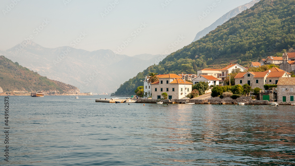 Beautiful Mediterranean seascape with houses tiled roofs on the background of mountains on a sunny day. High quality photo