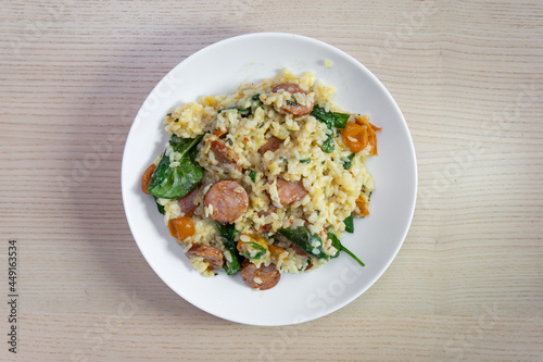 A plate of risotto with chorizo and spinach.