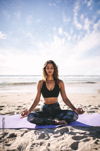 Fitness woman doing meditation on the beach