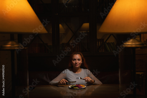 Portrait of beautiful woman eating grill salad, enjoying night life, luxury
