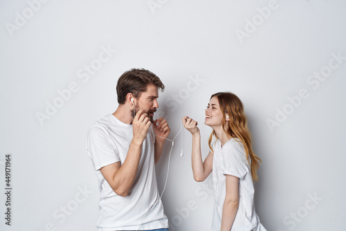 man and woman in white t-shirts are standing next to friendship fun light background