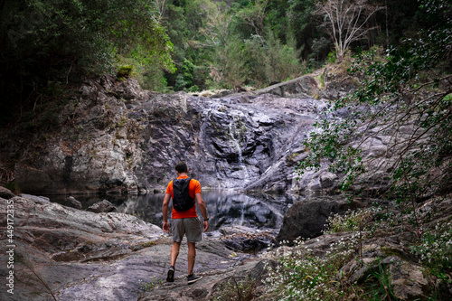 Bushwalker at rocky rainforest waterfall