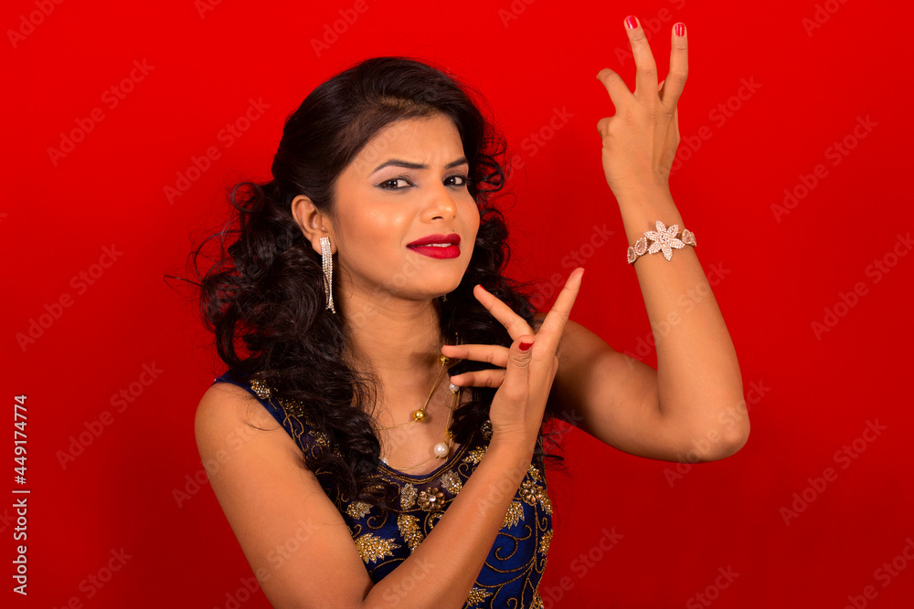 Naklejka premium Closeup of Indian young girl in blue dress with red background