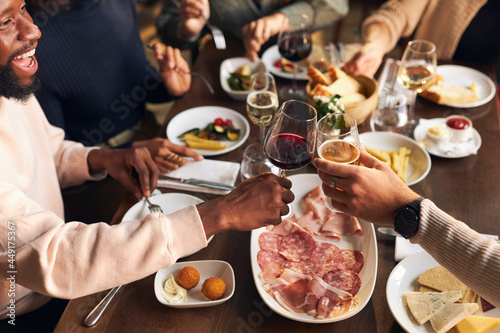 Canvas Print Friends toasting at dinner in restaurant