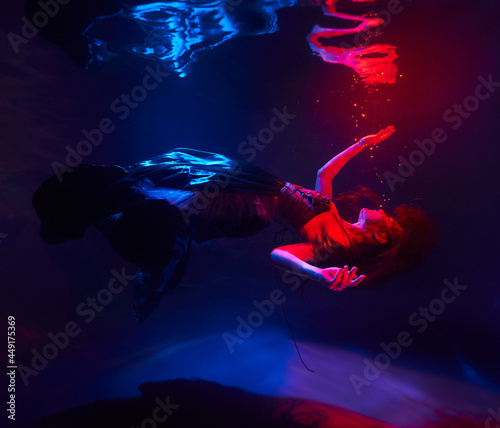 beautiful girl under the water in the light of the red moon