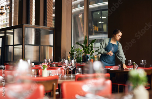 Female waitress setting tables photo