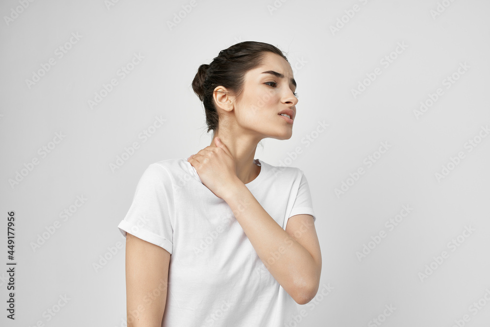 brunette in a white t-shirt holds on to the neck treatment brunette in a white t-shirt holds on to the neck treatment