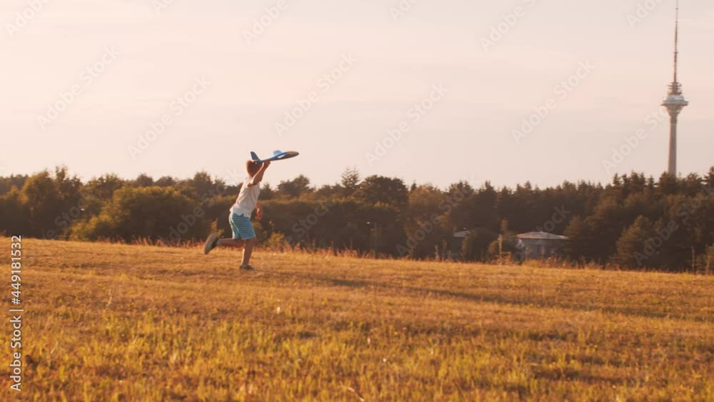 Boy plays with a toy plane in a field at sunset. The concept of childhood, freedom and inspiration. Boy plays with a toy plane in a field at sunset. The concept of childhood, freedom and inspiration.