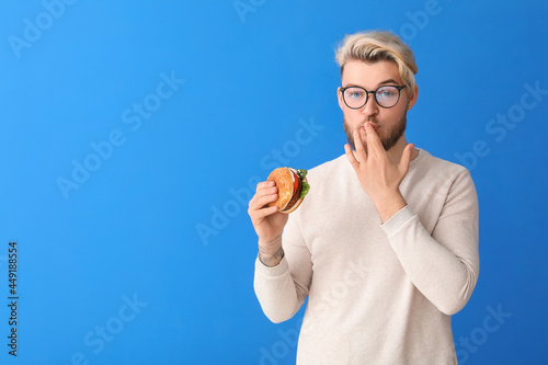 Young man eating vegan burg...