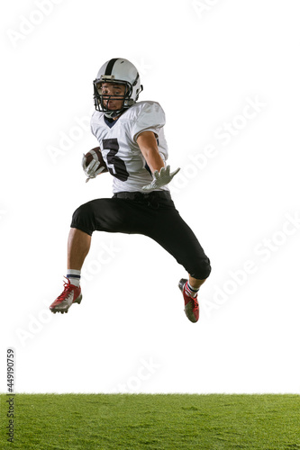 Portrait of American football player training isolated on white studio background with green grass. Concept of sport, competition © master1305