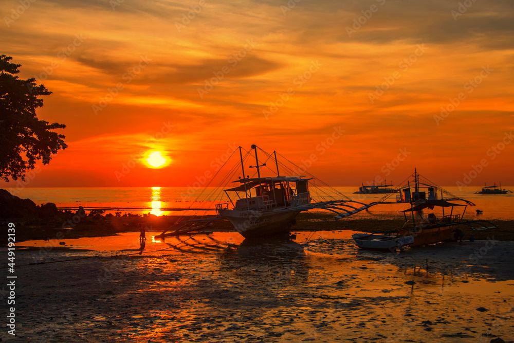 Fototapeta premium boat on a beach at sunset in philippines