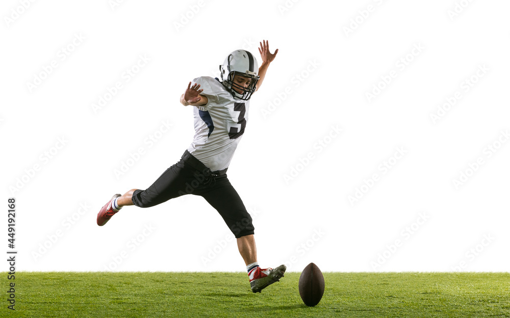 Portrait of American football player training isolated on white studio background with green grass. Concept of sport, competition